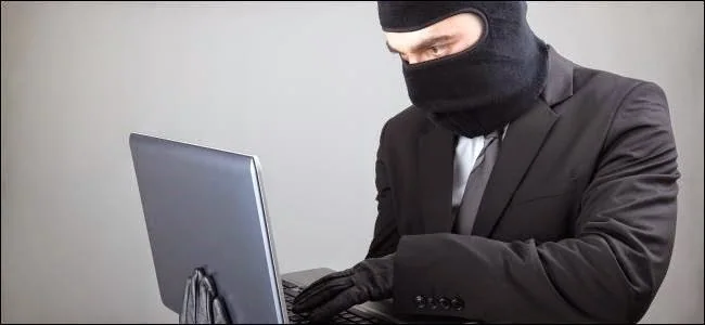 Masked person using a laptop.