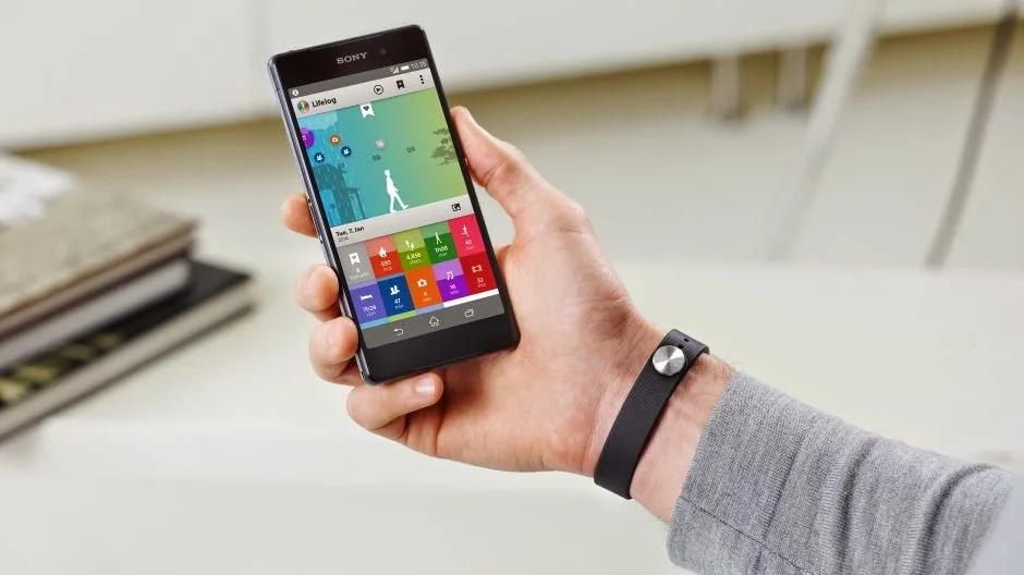 How to take a screenshot on the Sony Xperia Z2 Person wearing a smartwatch while holding a phone