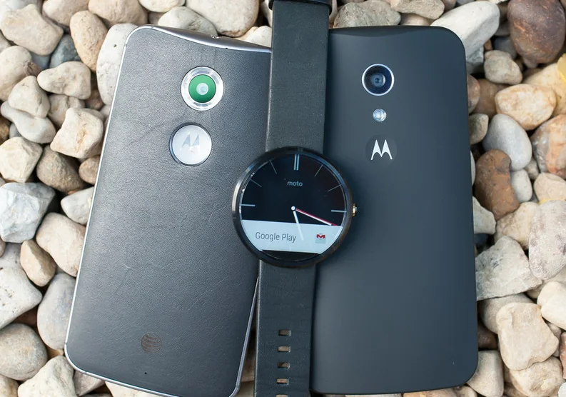 Two Motorola phones and a smartwatch on stones.